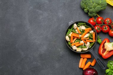 Lezzetli sebzeli tava ve koyu arka planda tavuk.