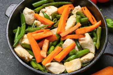 Lezzetli sebzeli tava ve koyu arka planda tavuk, yakın plan.