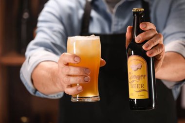 Barmen elinde şişe ve bir bardak taze zencefilli birayla barda