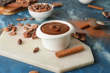 Arka planda bir kase lezzetli erimiş çikolata.