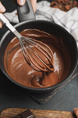 Koyu arkaplanda bir kase erimiş çikolata.