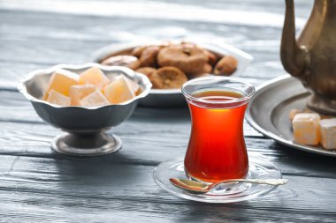 Sıcak Türk çayı ve ahşap zemin üzerinde bir kase tatlı.