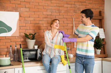 Genç çift mutfağını temizliyor.