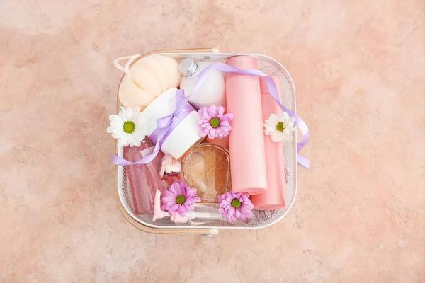 Gift basket with cosmetics on color background