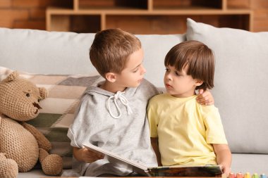 Evde kitap okuyan şirin çocuklar.