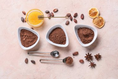 Bir kase kakao tozu, arkaplanda fasulye ve bal.