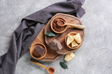 Tereyağlı kakao tozu ve gri arka planda çikolata.