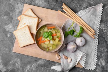 Gri arka planda lezzetli sarımsaklı çorba kasesi.