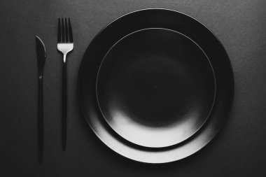 Koyu arkaplanda tabak ve çatal bıçak takımı