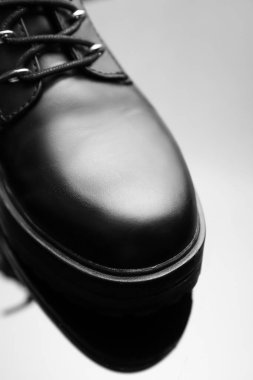 Gri arka planda deri kadın çizmesi, yakın plan.