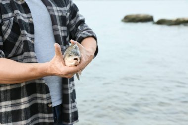 Nehir kıyısında balıklı adam