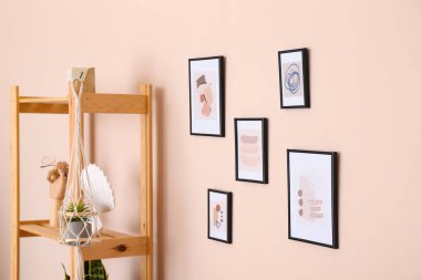 Odanın duvarında farklı resimler asılı.