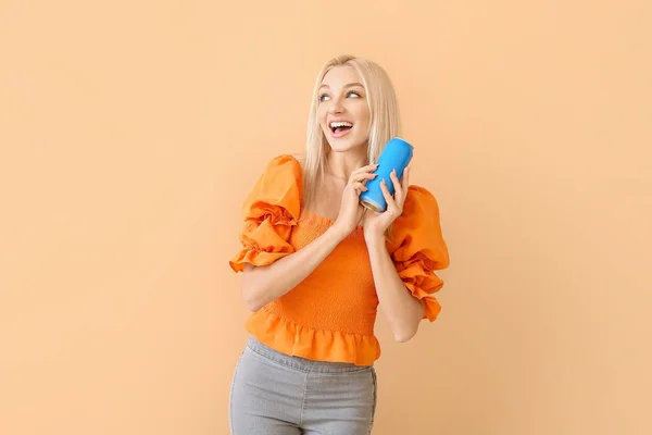 Beautiful young woman with soda on color background