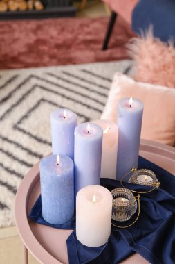 Odanın içinde yanan mumlarla dolu bir masa.