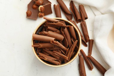 Kıvrımlı kase ve açık arkaplanda çikolata parçaları