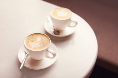 Kahve fincanları, kahve masasında latte sanat eserleri.