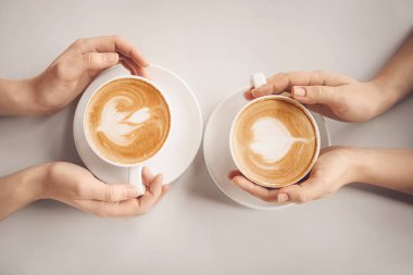 Masasında bir fincan latte olan kadınlar.