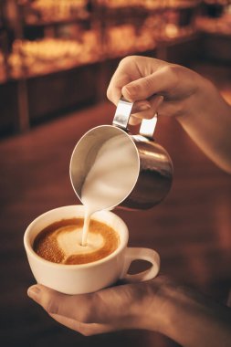 Kahveci kafede latte yapıyor.