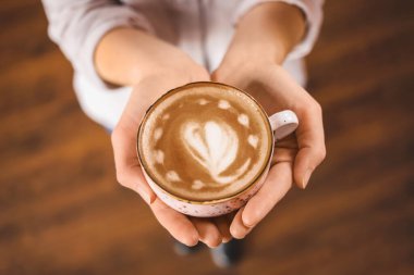 Kafede bir fincan latte içen kadın.