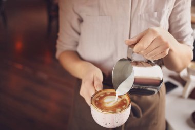 Kahveci kafede latte yapıyor.