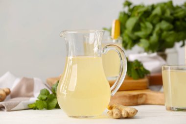 Hafif ahşap arka planda bir testi sağlıklı zencefil suyu.