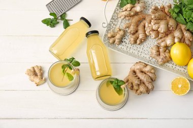Beyaz ahşap arka planda sağlıklı zencefil suyu içeren kompozisyon
