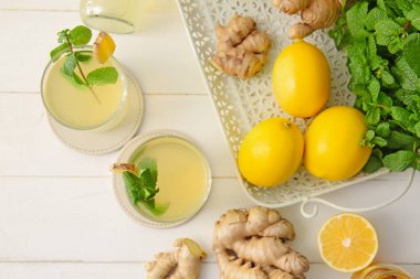 Beyaz ahşap arka planda sağlıklı zencefil suyu içeren kompozisyon