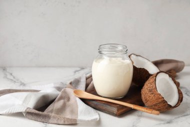 Hindistan cevizli yoğurt kavanozu masada.