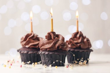 Bulanık arka planda mumları olan lezzetli çikolatalı kekler.