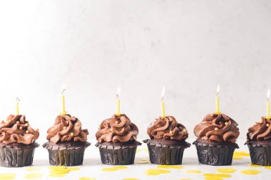 Hafif arka planda mumları olan lezzetli çikolatalı kekler.