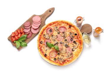 Beyaz arka planda lezzetli pizza ve malzemeler.