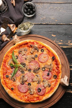 Koyu ahşap zemin üzerinde lezzetli pizzalar olan tahta.