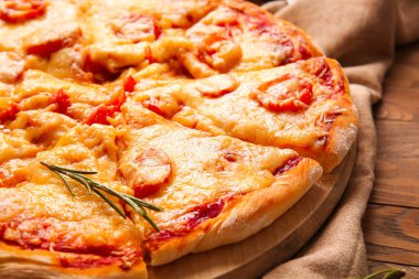 Ahşap zemin üzerinde lezzetli pizza olan tahta, yakın plan.