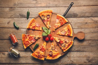 Ahşap arka planda lezzetli pizzalı kompozisyon