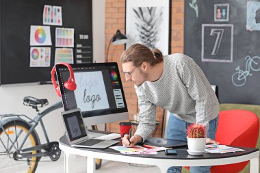 Genç erkek tasarımcı ofiste çalışıyor.