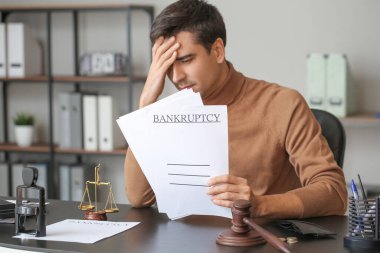 Masada kağıtları olan üzgün bir adam. İflas kavramı