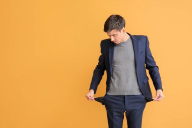 Renkli arka planda boş cepleri olan stresli bir adam. İflas kavramı