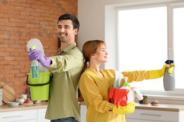 Mutfakta temizlik malzemeleri olan bir çift.