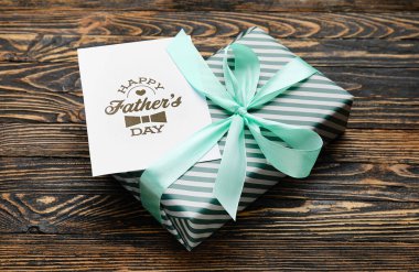 Babalar günü için tahta arka planda hediye kutusu ve tebrik kartı.