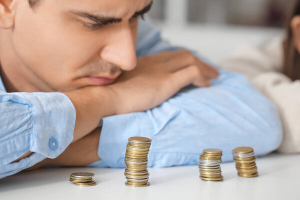 Sad young couple counting coins at home. Bankruptcy concept