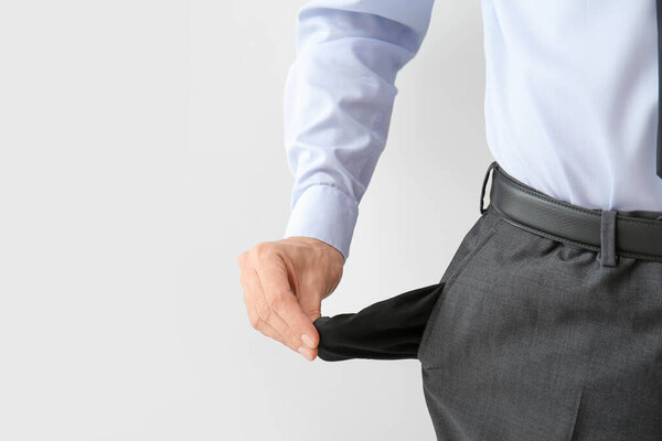 Бизнесмен с пустыми карманами на белом фоне, крупным планом. Концепция банкротства