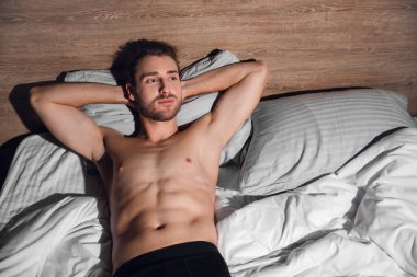Geceleri yatakta yatan seksi genç adam.