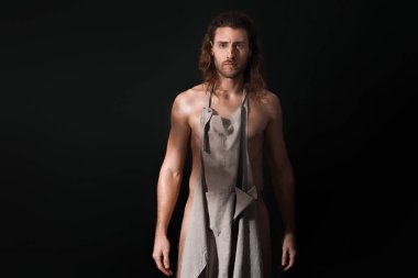 Geçmişi koyu renk önlüklü çıplak genç adam.