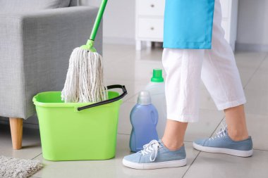 Genç bir kadın odayı paspaslıyor.