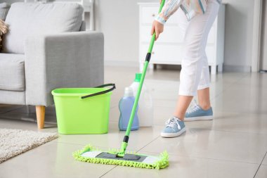 Genç bir kadın odayı paspaslıyor.