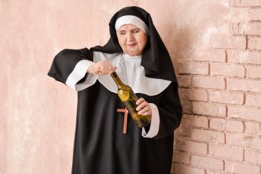 Senior nun with alcohol near color wall clipart