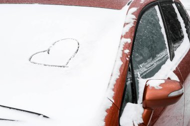 Kalp karla kaplı arabada çizilmiş.