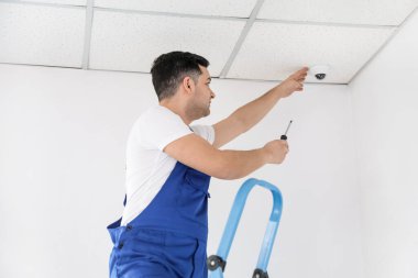 İşçi odaya kamera yerleştiriyor