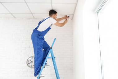 İşçi odaya kamera yerleştiriyor