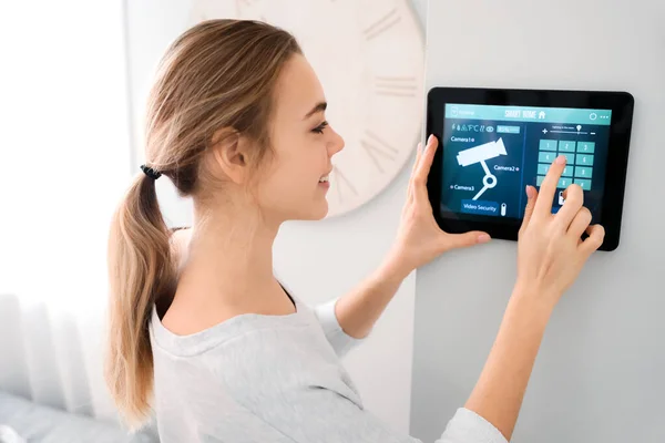 Woman using smart home security system control panel